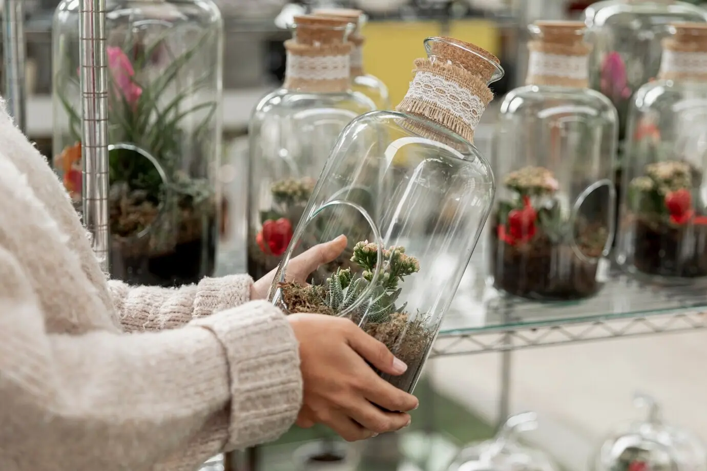 Close-up of a florist holding a transparent jar